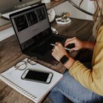 person in blue denim jeans using macbook pro